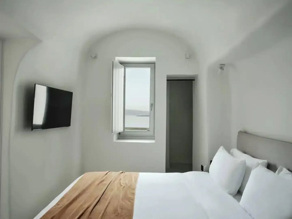 Helles Schlafzimmer mit Doppelbett und seitlichem Meerblick