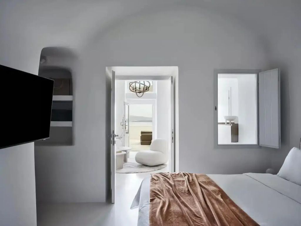 Blick durch offenes Schlafzimmer in helles Wohnzimmer mit Meerblick