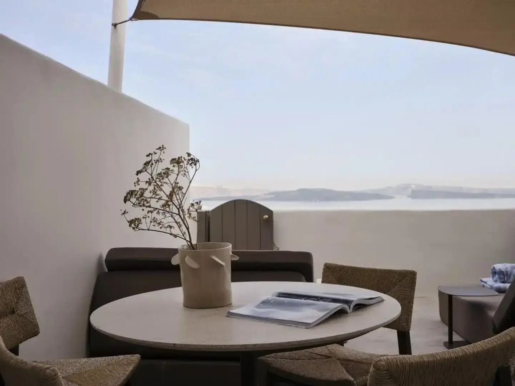 Terrasse mit Tisch und Stühlen vor atemberaubendem Meerblick