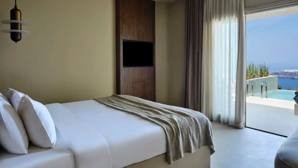 Komfortables Doppelbett in heller Suite mit Vorhang und Fernseher