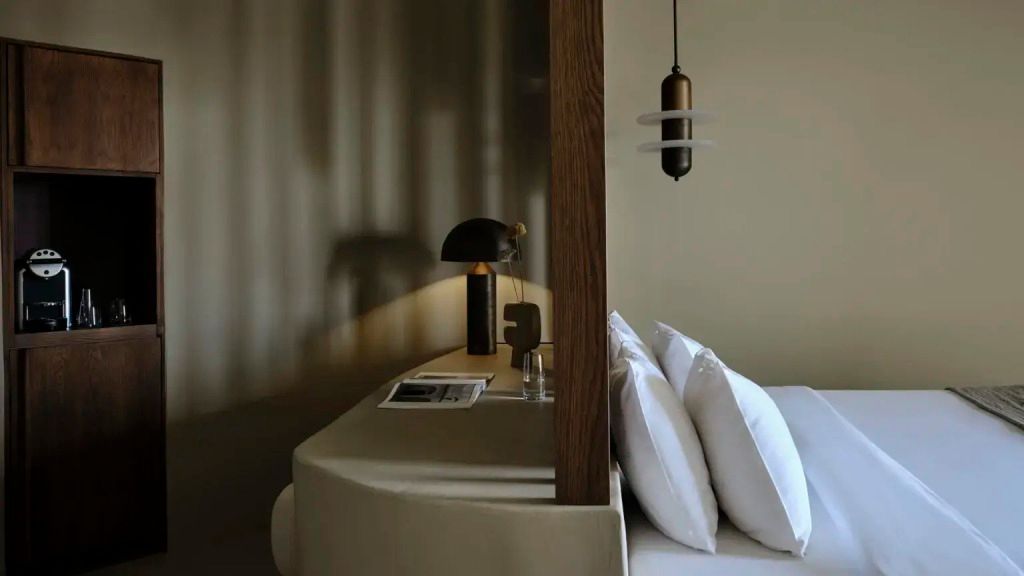 Schreibtisch mit Lampe und modernen Akzenten neben dem Bett