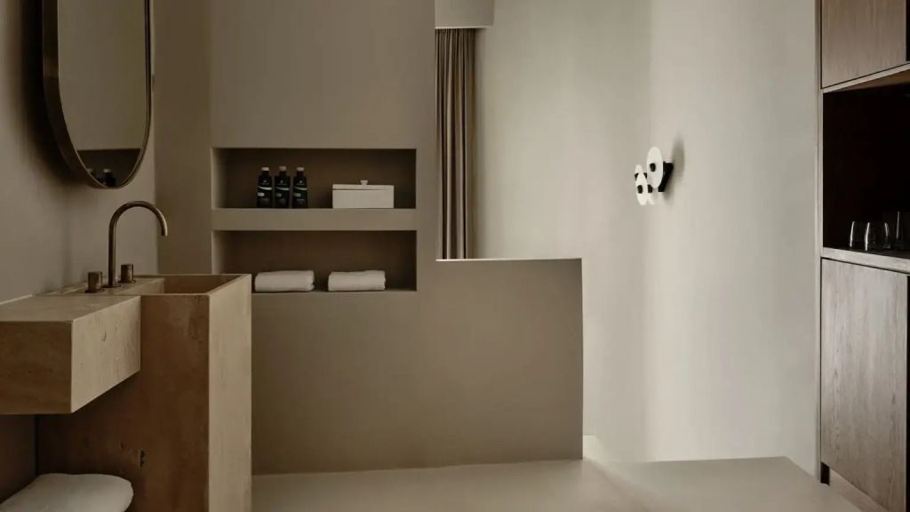 Minimalistisches Badezimmer-Design mit Handtüchern und Pflegeprodukten.