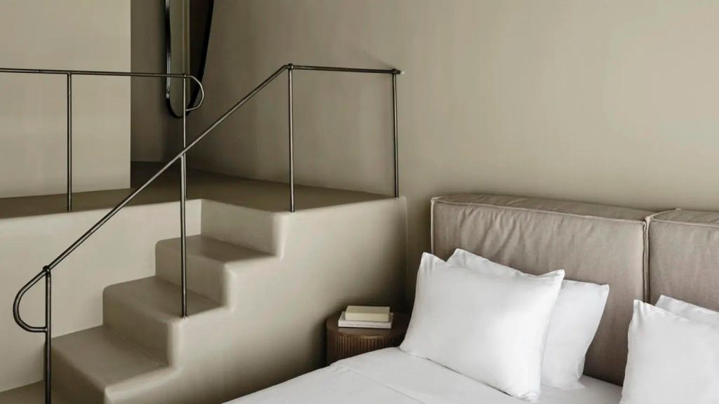 Komfortables Schlafzimmer mit modernem Interieur und Treppe.