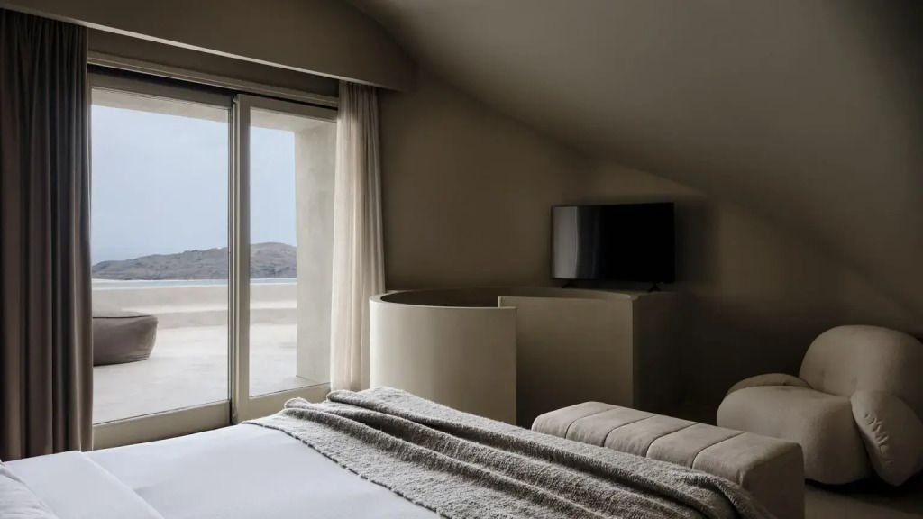 Luxuriöses Schlafzimmer mit großem Fenster und Blick auf Terrasse und Landschaft