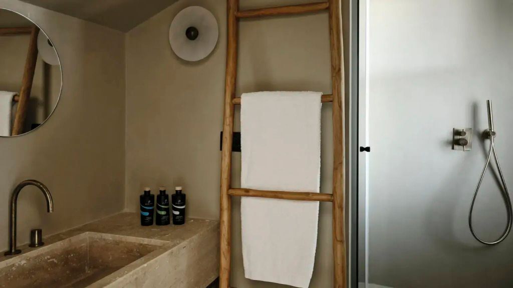 Badezimmer mit Holzleiter-Handtuchhalter und stilvoller Beleuchtung