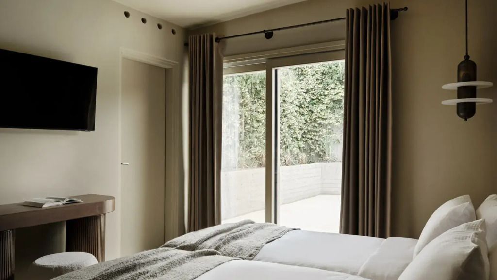 Schlafzimmer mit großen Fenstern zur Terrasse und blickdichten Vorhängen