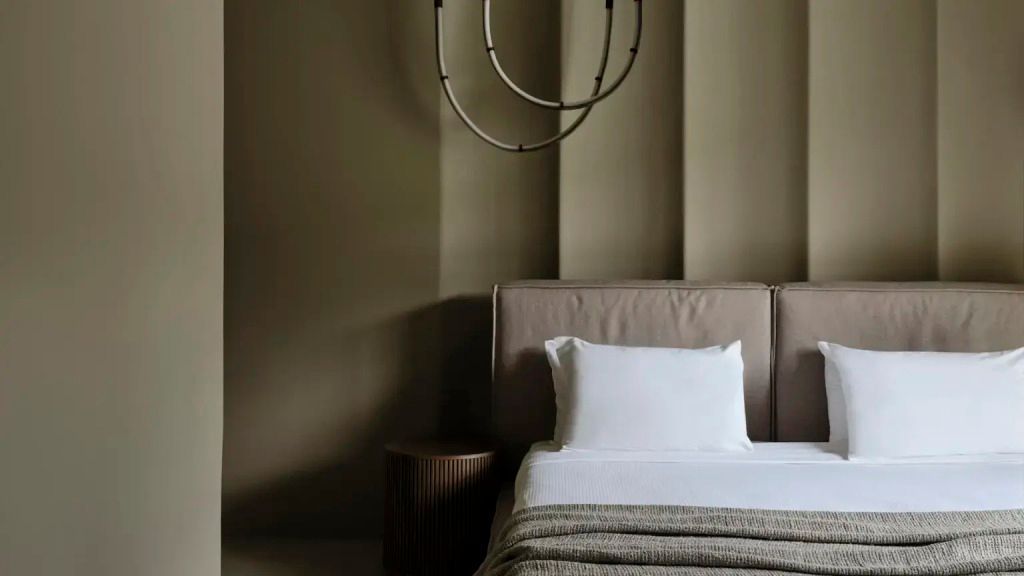 Einzelbett mit stilvoller Beleuchtung und minimalistischen Details