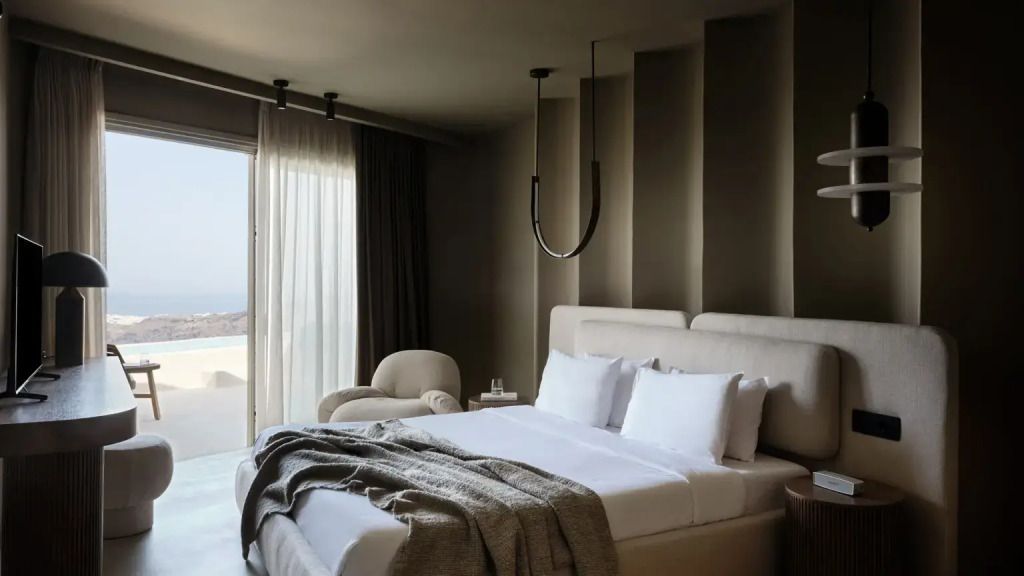 Elegantes Doppelbett in moderner Suite mit stilvoller Beleuchtung und großen Fenstern