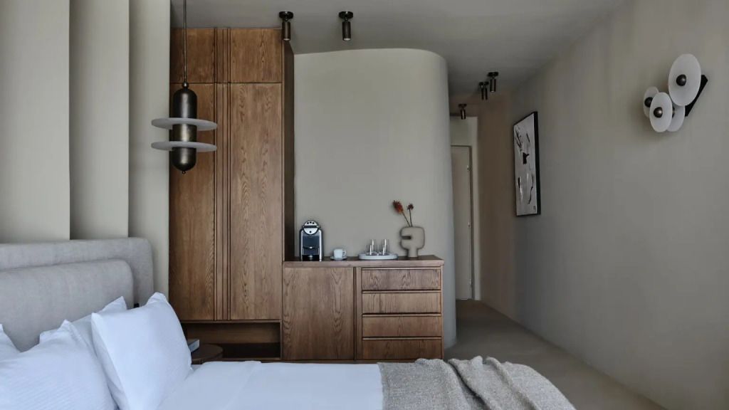 Doppelbett in schicker Suite mit Holzkommode und dezenter Dekoration im Flur