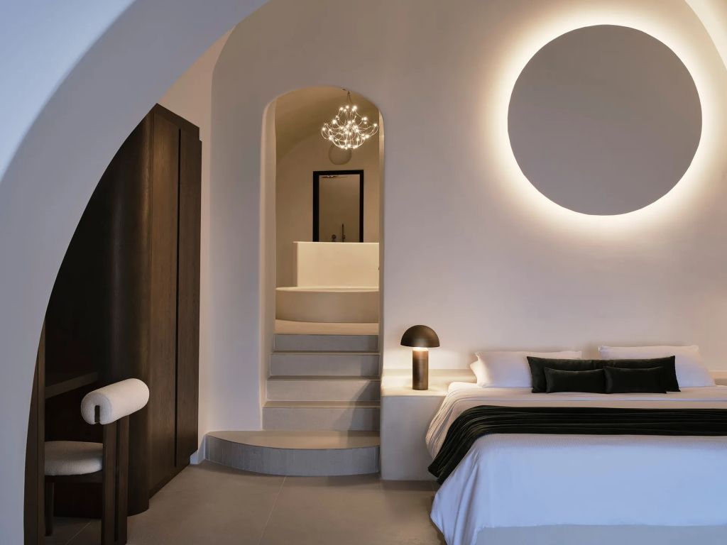Moderner Schlafbereich mit Treppenstufen zum eleganten Badezimmer und sanfter Beleuchtung