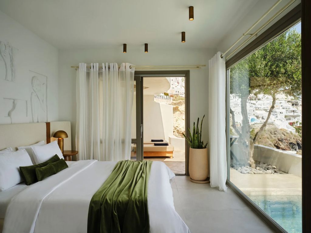 Helles Schlafzimmer in der Suite mit großen Fenstern und Zugang zur Terrasse