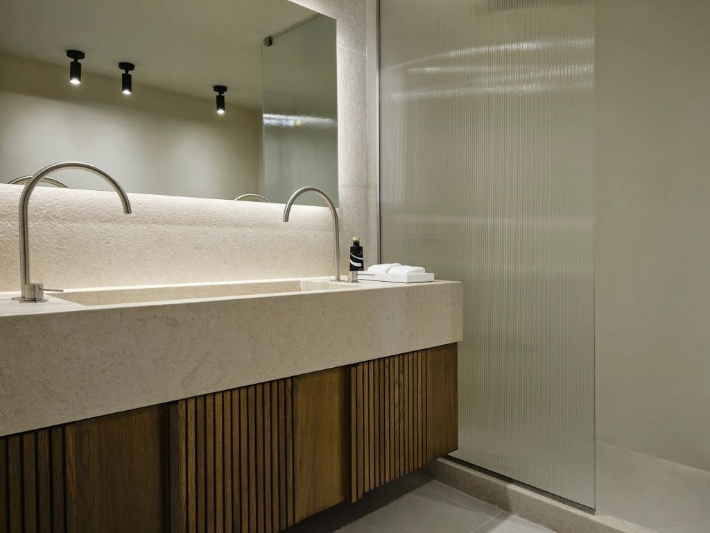 Modernes Badezimmer mit großem Waschbecken und beleuchtetem Spiegel