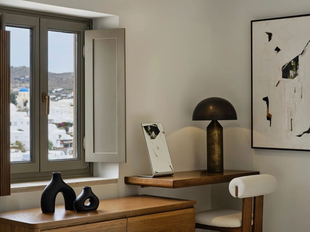 Schreibtisch mit Kunstobjekten und Fensterblick auf Santorini