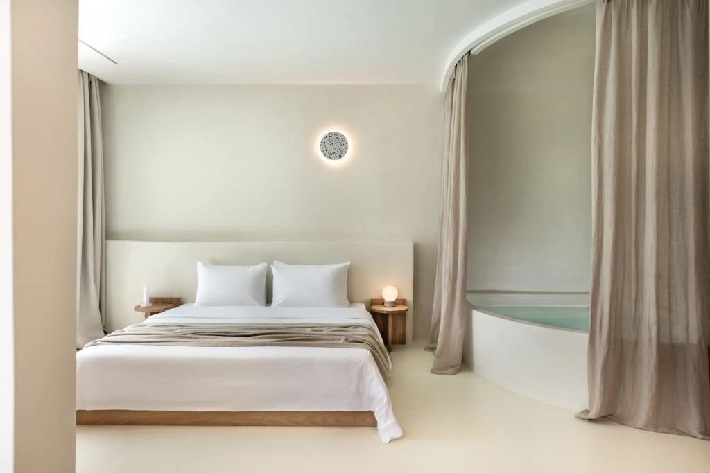 Schlafzimmer mit rundem Jacuzzi und dezenter Beleuchtung