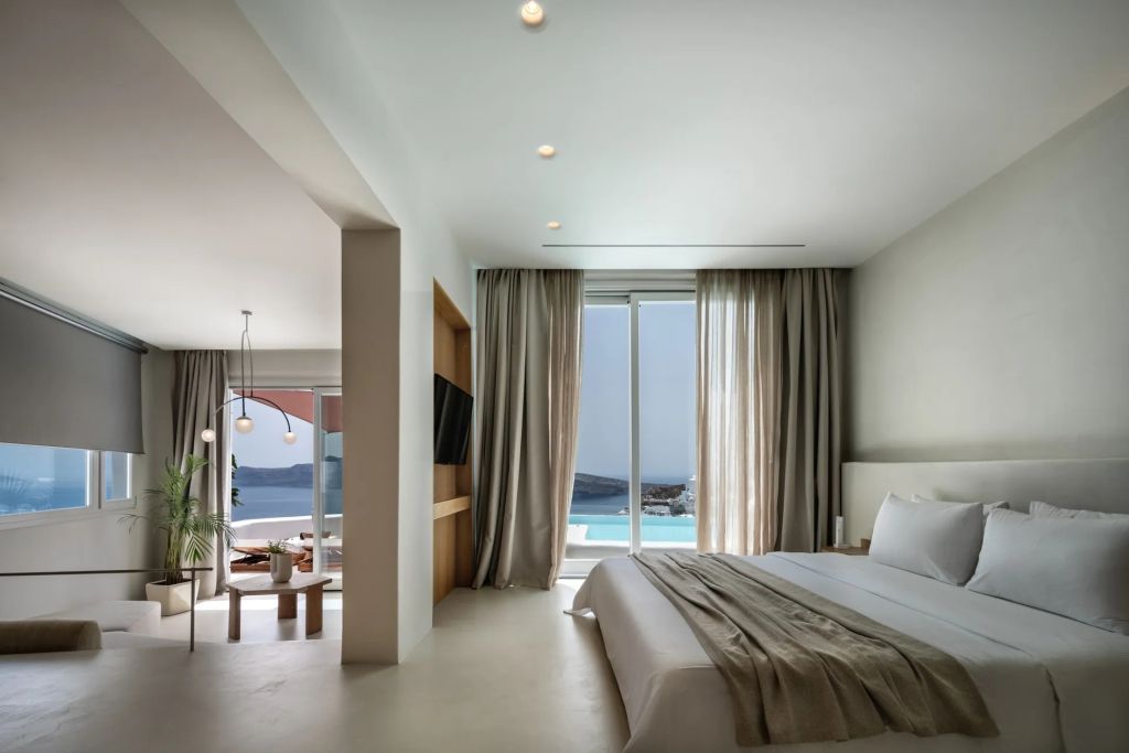 Moderne Suite mit großem Fenster und Blick auf den Pool