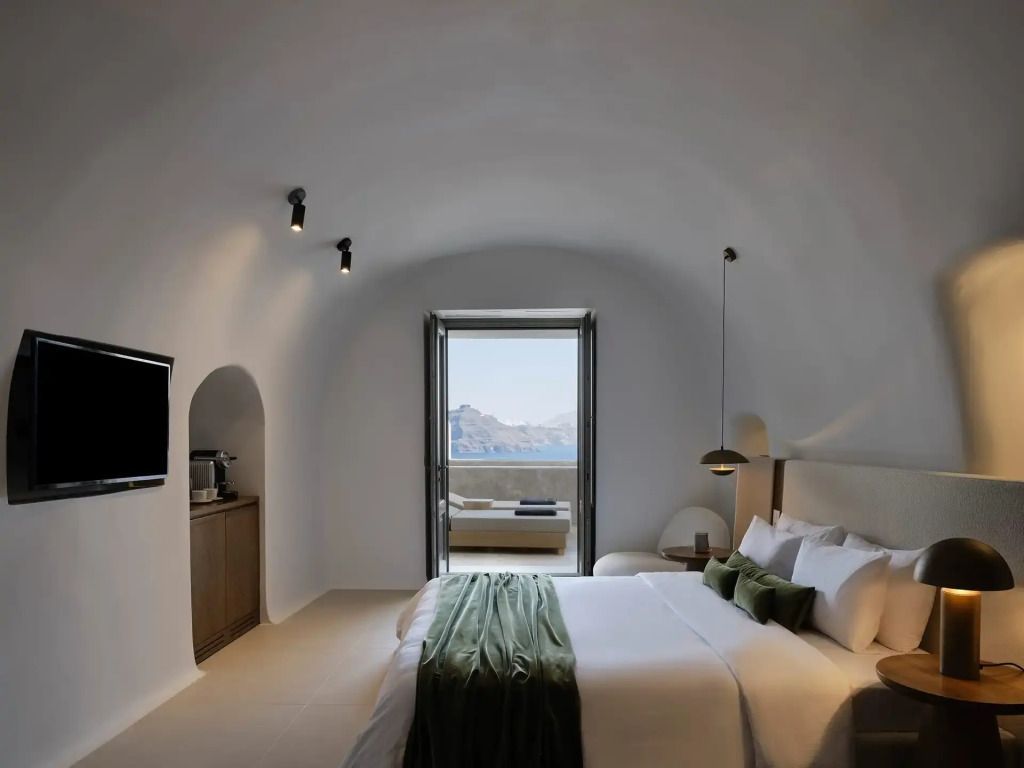 Elegantes Schlafzimmer mit gewölbten Decken und Balkonblick auf das Meer