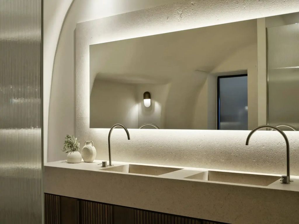 Elegantes Badezimmer mit großem beleuchtetem Spiegel und Doppelwaschbecken