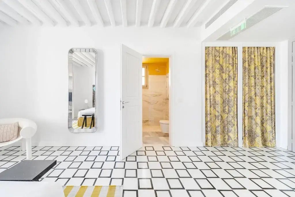 Blick auf das Badezimmer und die stilvollen gelben Akzente des Deluxe Doppelzimmers.