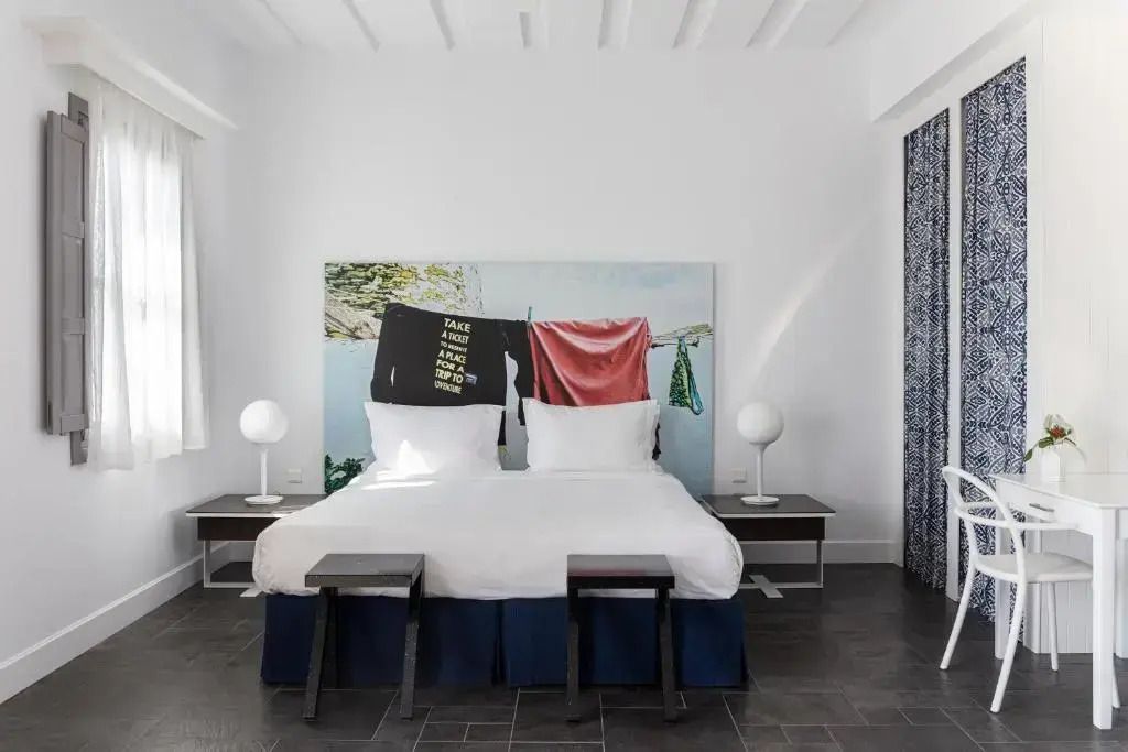 Modern eingerichtetes Doppelzimmer mit künstlerischem Wandbild und stilvollen Möbeln