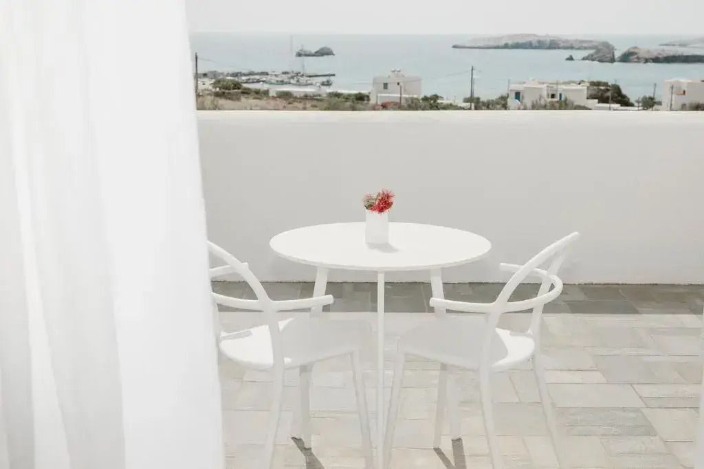 Terrasse mit Meerblick und stilvollem weißen Tisch und Stühlen