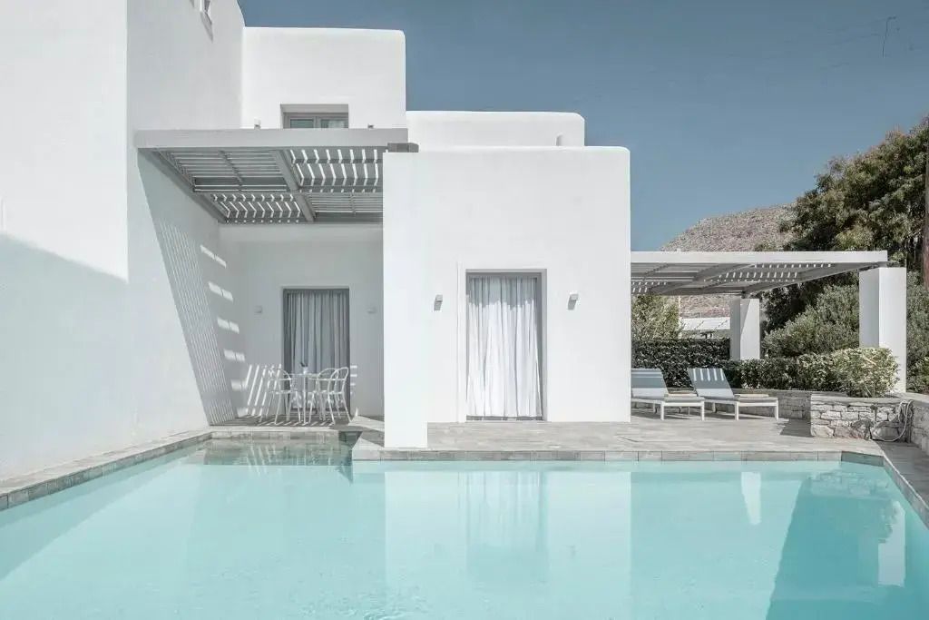 Moderner Infinity-Pool mit weißer Gebäude-Architektur im Hintergrund