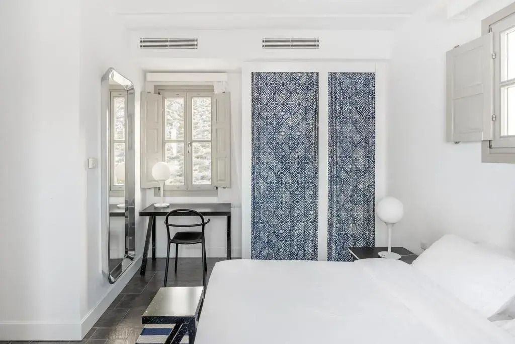 Helles Schlafzimmer mit Schreibtisch und Fenster mit Blick nach draußen
