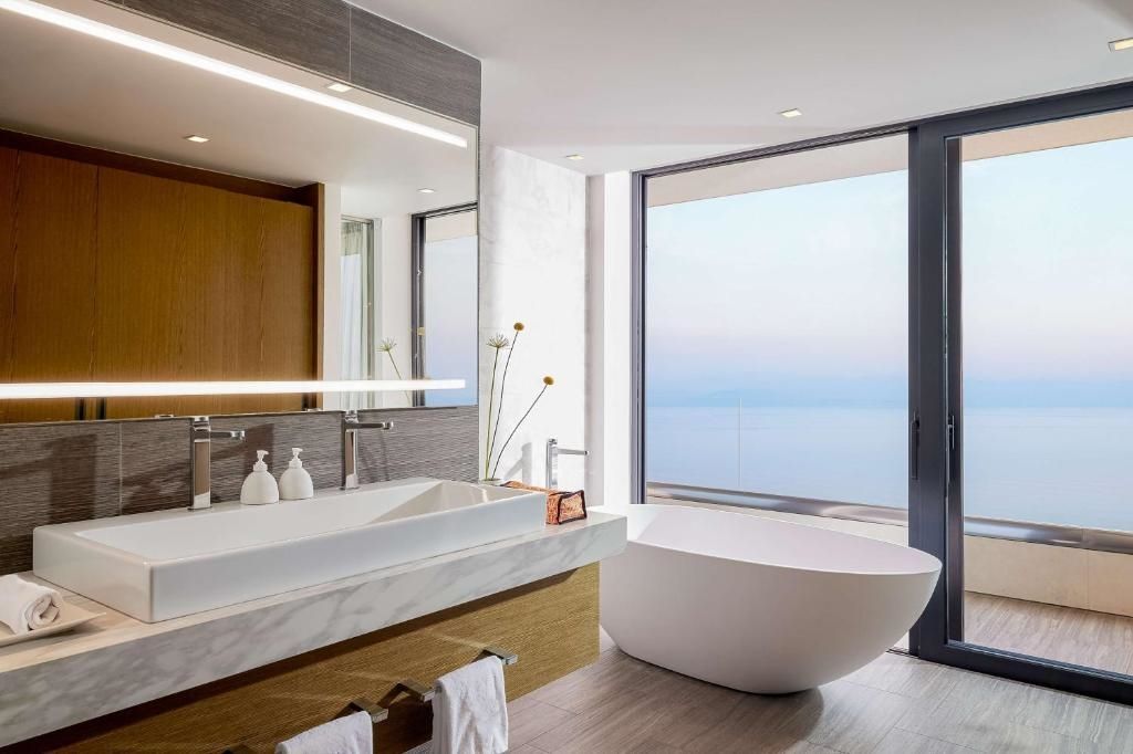 Modernes Badezimmer mit freistehender Badewanne und Meerblick