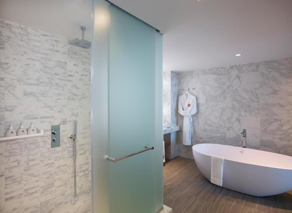 Freistehende Badewanne und Regendusche in elegantem Badezimmer im Angsana Corfu Resort