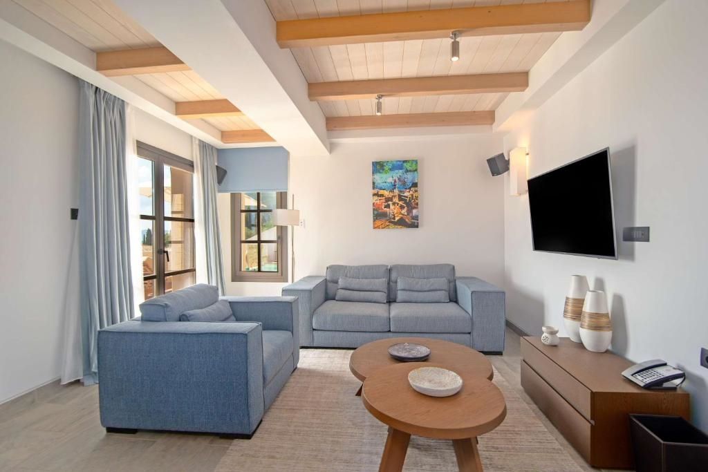 Wohnzimmer mit zwei blauen Sofas, Couchtisch und großem Fenster. Moderne Einrichtung.