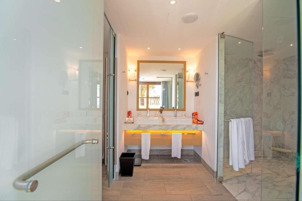 Badezimmer mit modernem Waschbecken, Duschbereich und natürlichem Licht