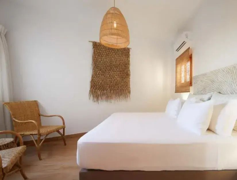 Geräumiges Schlafzimmer mit rustikalem Lampenschirm und Kunstwerk an der Wand