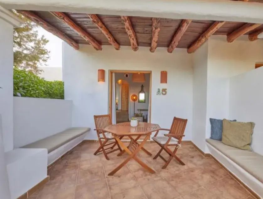 Überdachte Terrasse mit Holzmöbeln und gemütlicher Sitzbank