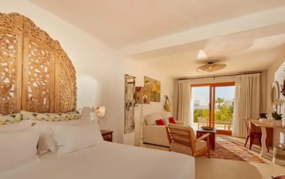 Helles Schlafzimmer mit stilvollen Möbeln und Zugang zum Balkon.