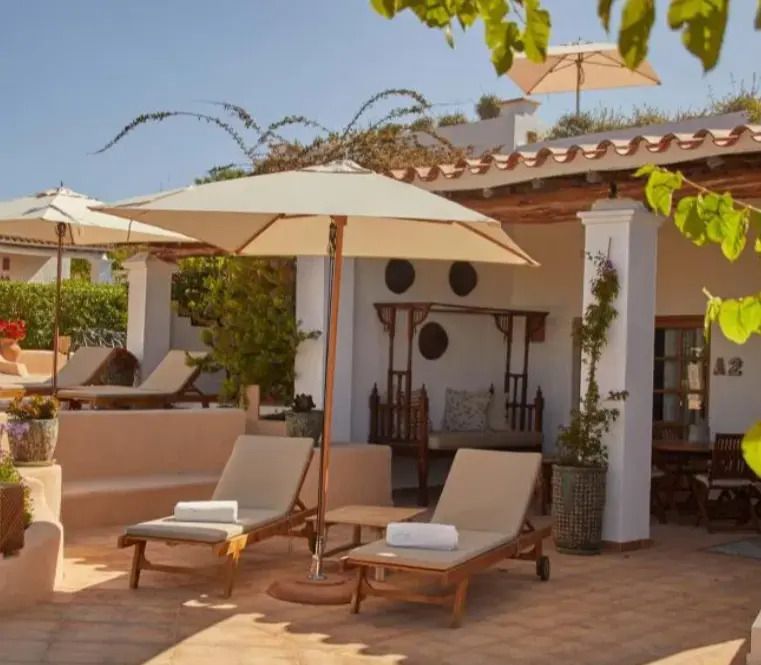 Sonnige Terrasse mit Liegestühlen und Sonnenschirmen