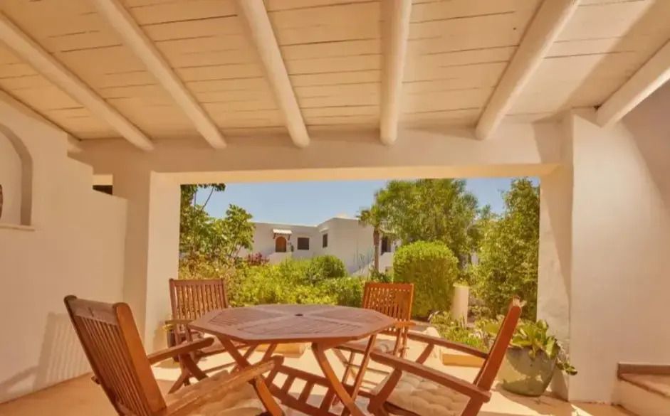 Gartenblick von einer überdachten Terrasse mit Holzmöbeln
