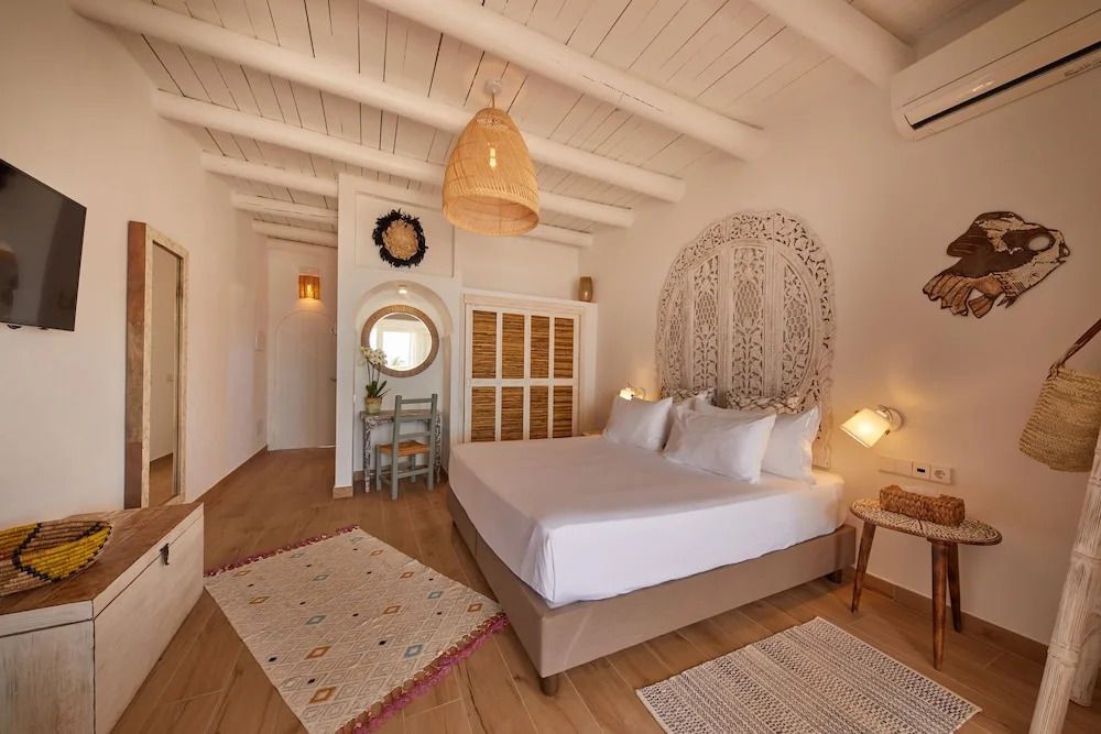 Helles Zimmer mit Doppelbett, Holzakzenten und Dekor in Ibiza-Stil