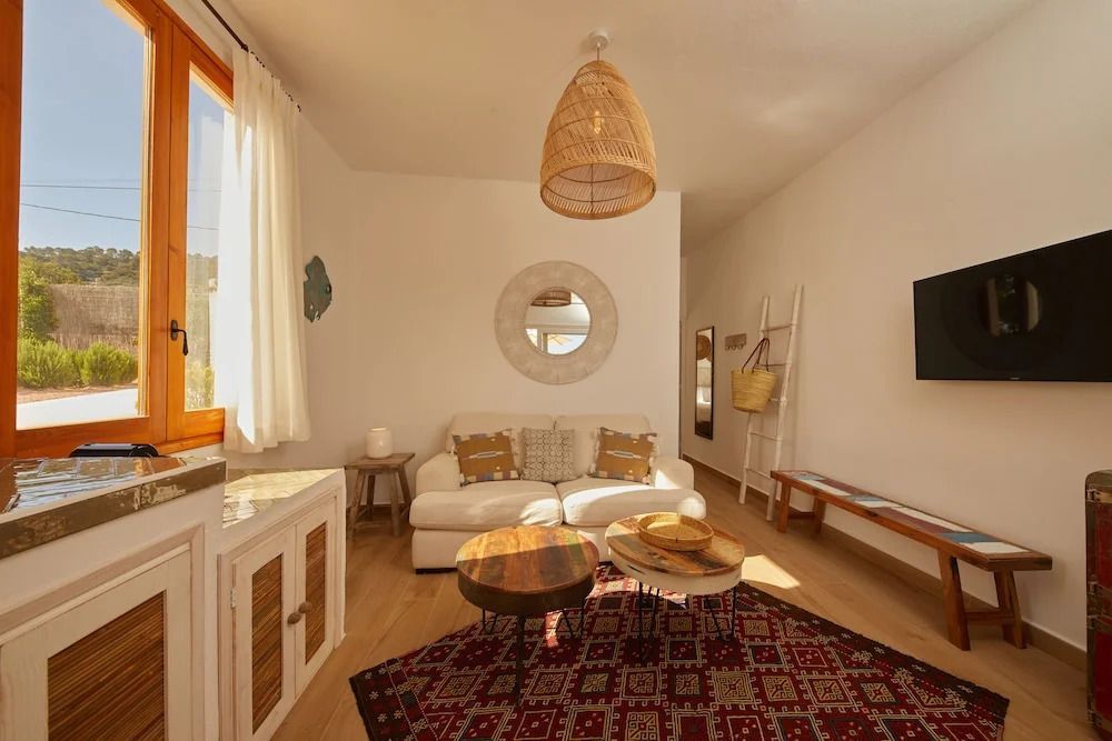 Geräumiger Wohnbereich mit Sofa, rundem Spiegel und traditionellem Teppich