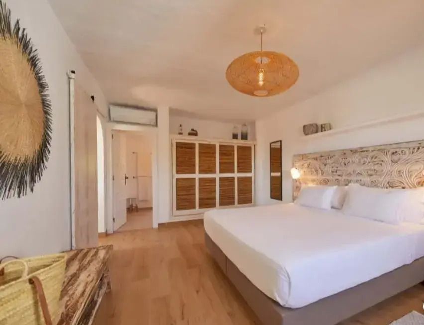 Modern eingerichtetes Schlafzimmer mit großem Schrank und Doppelbett in warmen Tönen.
