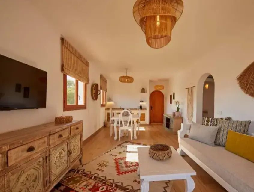 Geräumiger Wohnbereich mit Esstisch und rustikaler Holzmöblierung in der Suite.