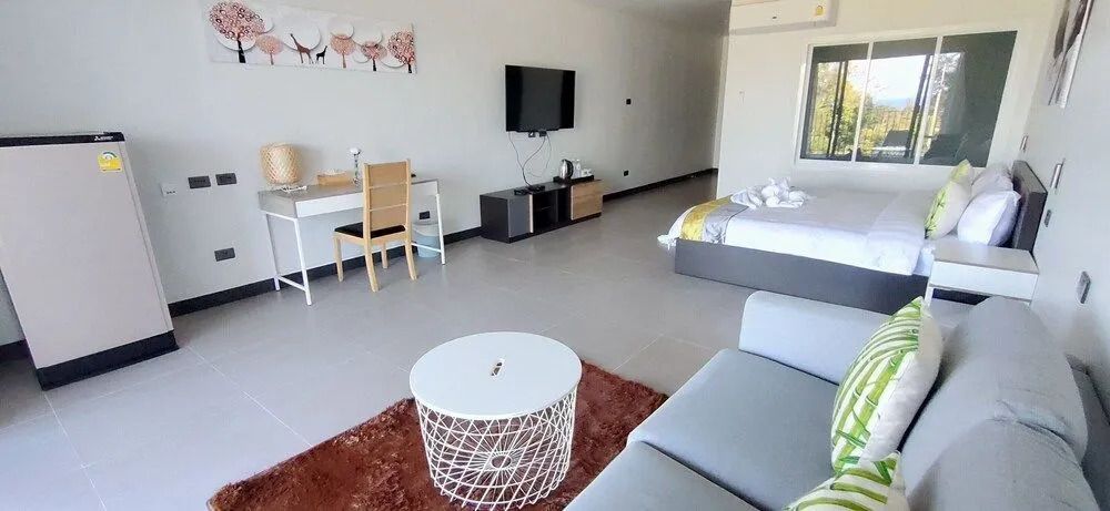 Elegantes Zimmer mit modernem Dekor, Schreibtisch, Sofa und Fernseher im Pimalai Resort