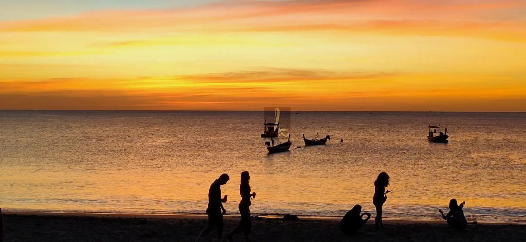 Romantischer Sonnenuntergang am Strand mit traditionellen Booten
