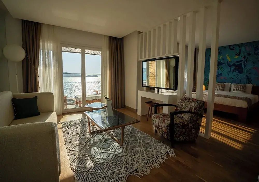 Wohnbereich im Zimmer mit Blick auf den Balkon und das Meer durch große Fenster