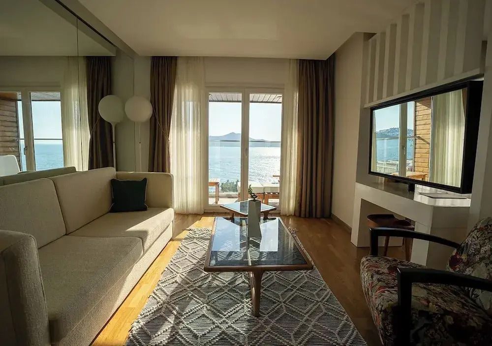 Moderner Wohnbereich mit Sofas und Meerblick durch Glasfenster
