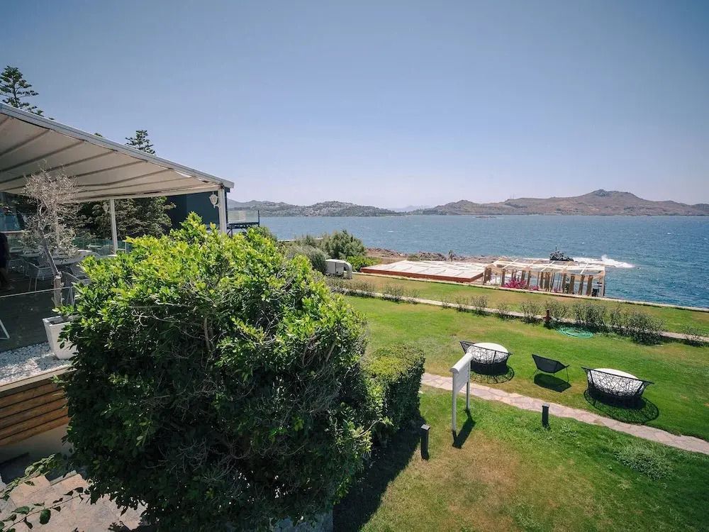 Weitläufiger Blick über den Garten auf das Meer bei klarem Himmel