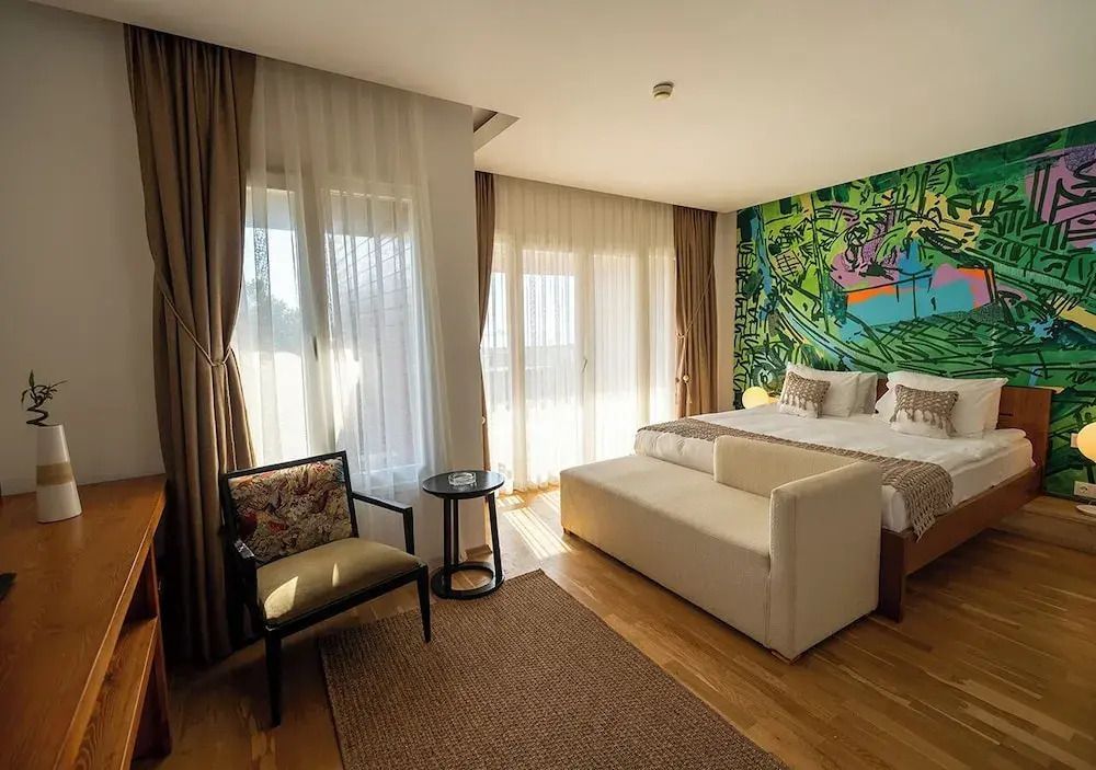 Komfortzimmer mit eleganter Inneneinrichtung und farbenfrohem Wandbild