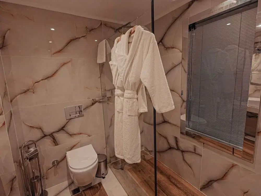 Luxuriöses Badezimmer mit Bademantel und Marmorverkleidung