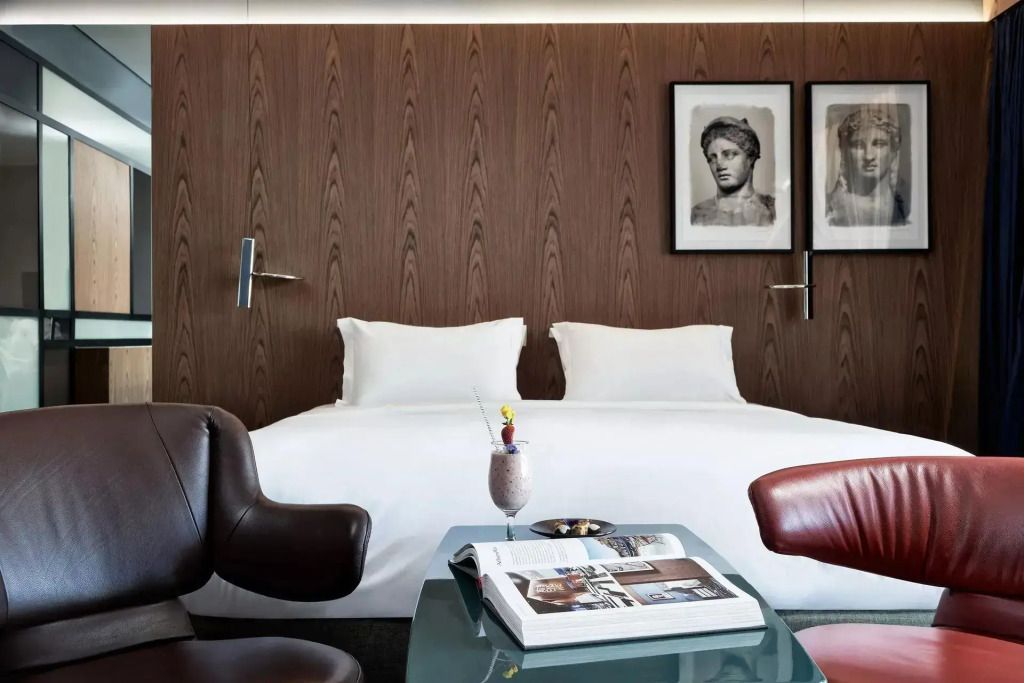 Stilvolles Doppelzimmer mit modernen Sesseln und Kunstwerken an der Wand