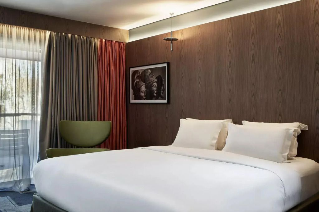 Modernes Hotelzimmer mit Doppelbett Holzverkleidung und eleganter Beleuchtung