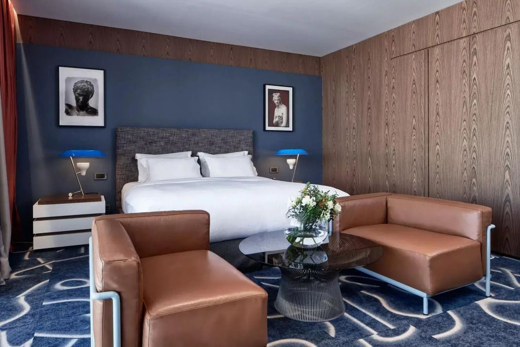Geräumige Suite mit bequemen Ledersesseln und elegantem Doppelbett