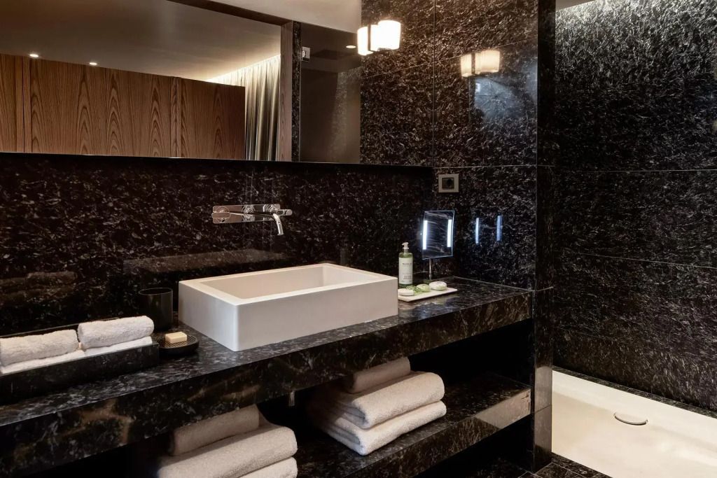 Luxuriöses Badezimmer mit modernem Schwarz-Weiß-Design und stilvollen Beleuchtungselementen